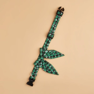 Detail of green buffalo plaid dog collar with white snowflakes and metal D-ring buckle