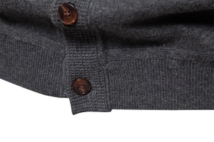 Close-up of dark grey knitted cardigan with premium brown resin button details