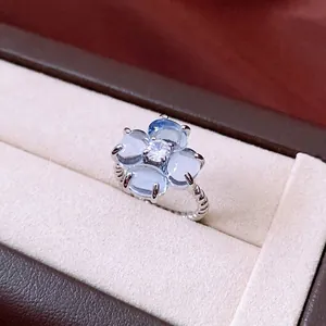 Sparkling zircon flower open ring with blue gemstones and a twisted silver rope band