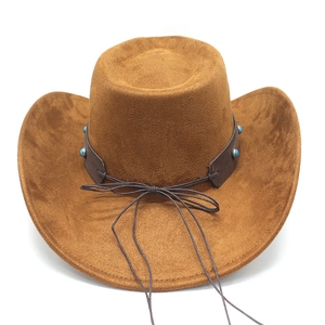 Detail of caramel brown faux suede cowboy hat with turquoise studded leather band decoration