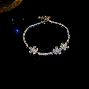Macro shot of Zircon flower pendant bracelet with sparkling crystal chain on black background