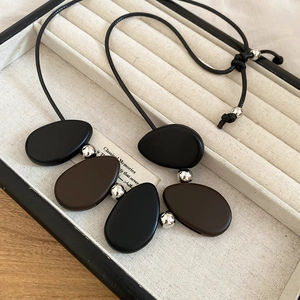 Detail of vintage resin pendant necklace with matte brown and black oval beads on cord