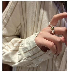 Close-up of mixed metal silver band with gold bean detail and pearl bead ring