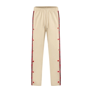 Detail of men's casual pants showing side plaid stripe and red snap buttons on beige fabric