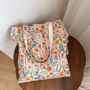 Sac fourre-tout en coton imprimé fleuri posé sur une table basse en bois foncé