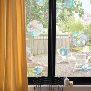 Detailed view of circular holographic rainbow prism window stickers on glass pane