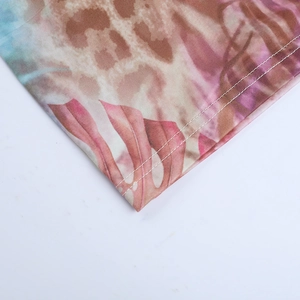 Detail of leopard and pink leaf print fabric with precise double stitching on the edges