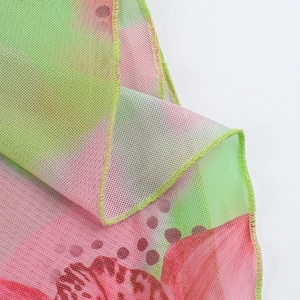 Macro shot of floral mesh fabric showing breathable pink and green gradient mesh texture