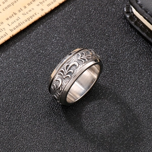 Close-up of vintage titanium steel ring featuring intricate floral engraving and polished inner
