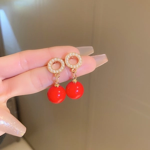 Detailed close-up of vintage red pearl drop earrings with elegant gold circle links