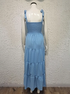 Detail of blue jacquard fabric with backless smocked design and bow tie straps on dress