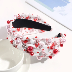 Detail of white knotted headband with red hearts, teddy bears and faux pearl beads