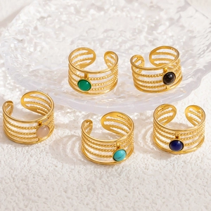 Macro detail of five adjustable 18k gold plated stainless steel rings with colorful gemstones