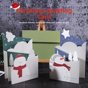 Detail of 3D Christmas pop-up greeting cards with snowman and tree on wooden desk