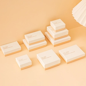 Chic white and peach paper jewelry gift boxes with gold text for elegant packaging