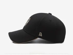 Side view detail of black baseball cap featuring golden side embroidery and shield badge