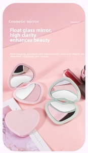 Close-up of heart-shaped folding makeup mirrors in pink and green matte finishes