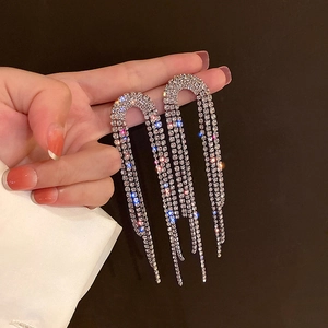 Sparkling silver long fringe tassel earrings with rhinestones held in hand for display