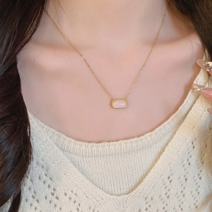 Gros plan d'un collier plaqué or 18 carats avec pendentif rectangulaire en résine rose