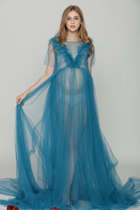 Dettaglio di un abito da maternità blu con lungo strascico in tulle per foto in studio
