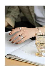 Close-up of S925 sterling silver coin ring and rope band on model in retro setting