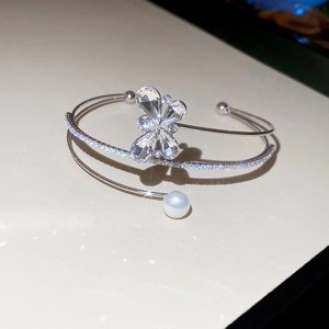Detailed macro view of silver flower bracelet with zircon stones and a white pearl