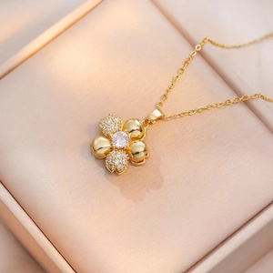 Collar con colgante de flor de cuatro pétalos en oro con circonitas en estuche de joyería