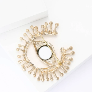 Detailed back view of gold evil eye brooch showing secure safety pin clasp closure