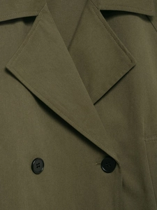 Close-up of olive green double-breasted trench coat with black resin buttons and twill texture