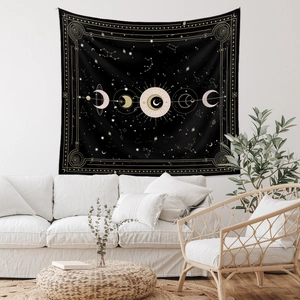 Detail of a mystical black moon phase tapestry hanging in a bohemian style room setting