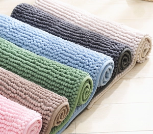 Detail of rolled chenille bath mats in multiple colors showing plush non-slip texture