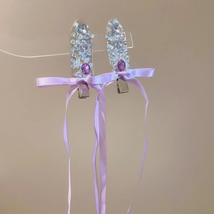 Detail of purple ribbon bow hair clips with blue sequins and teardrop gemstone