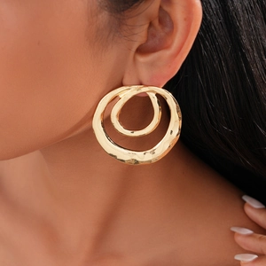 Close-up of hammered gold double hoop earrings featuring a textured geometric design