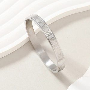 Polished silver stainless steel bangle with roman numeral engraving on wave texture background