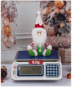 Macro view of Christmas gnome plush scale measurement weighing 62 grams on holiday background