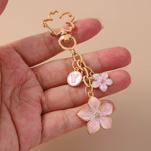 Pastel pink cherry blossom keychain with golden flower hook and letter Y pendant