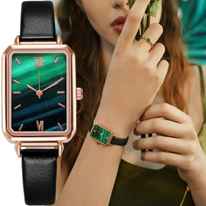Detail of vintage rectangular green dial watch with gold case and black leather strap