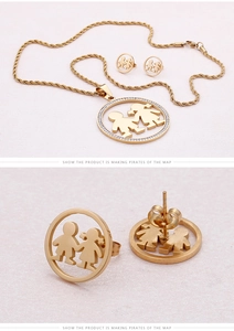 Détail de parure dorée en acier titane avec pendentifs garçon et fille et strass