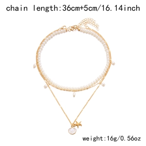 Detail of layered seashell and starfish necklace with pearls and 36cm chain length specs