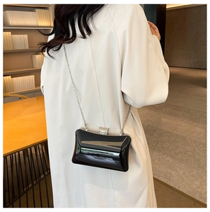 Nahaufnahme der schwarzen glänzenden Acryl-Box-Tasche mit Silberkette und Strassverschluss