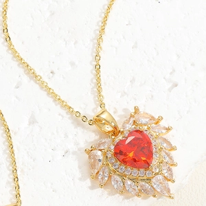 Macro detail of luxury heart-shaped red zircon pendant with marquise white diamond halo