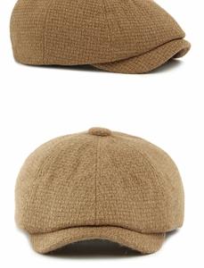 Detailed close-up showing the warm camel knit texture and top button of the newsboy cap