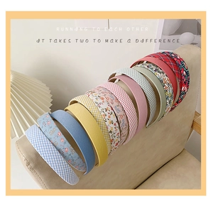 Detail view of 12 colorful floral and plaid fabric headbands displayed on a chair