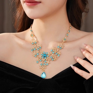 Detailed close-up of a vintage golden floral necklace featuring blue zircon water drop pendants