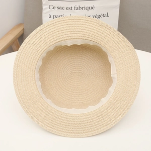 Detailed interior of a minimalist beige straw sun hat with white sweatband weaving