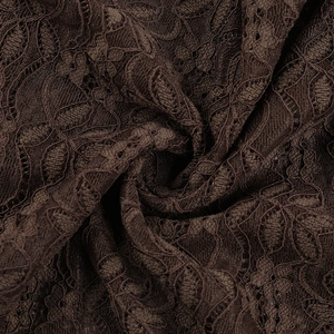 Gros plan sur un tissu en dentelle marron foncé avec motifs floraux et détails ajourés