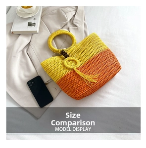 Flat lay of gradient straw tote bag with round handles and tassel detail in a lifestyle set