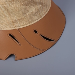 Cappello a secchiello in rafia beige con tesa in pelle marrone e intagli a foglia