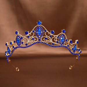 Baroque gold bridal crown with deep blue rhinestones on a brown silk background