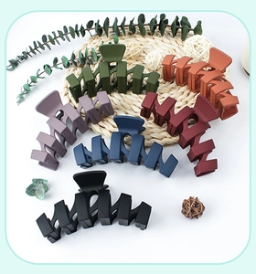 Matte wavy hair claw clips in six colors displayed on a rustic decorative surface